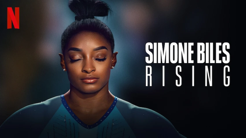 An image of Simone Biles with her eyes closed and hair in a bun, wearing what looks like a gymnastics leotard. To the side are the words "Simone Biles Rising" and in the top left is the Netflix logo.